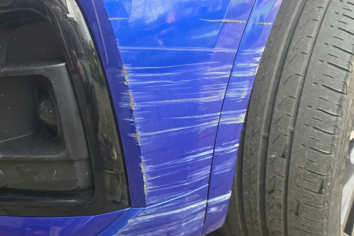 Scraped front corner on a blue hatchback bumper